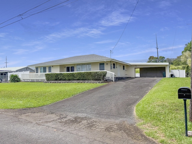 single story home with a front lawn, a carport, fence, and driveway