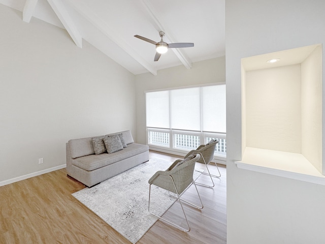 living room with light wood-style flooring, vaulted ceiling with beams, a ceiling fan, and baseboards