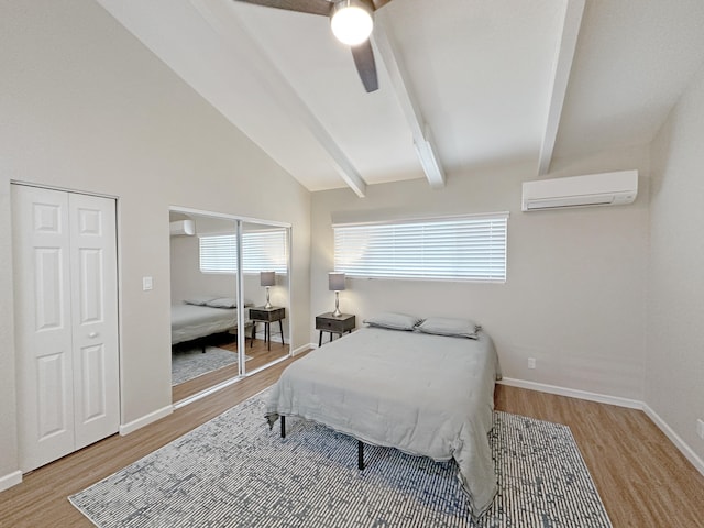 bedroom with a ceiling fan, lofted ceiling with beams, wood finished floors, and a wall mounted air conditioner