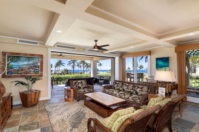 living room featuring stone tile flooring, visible vents, and baseboards