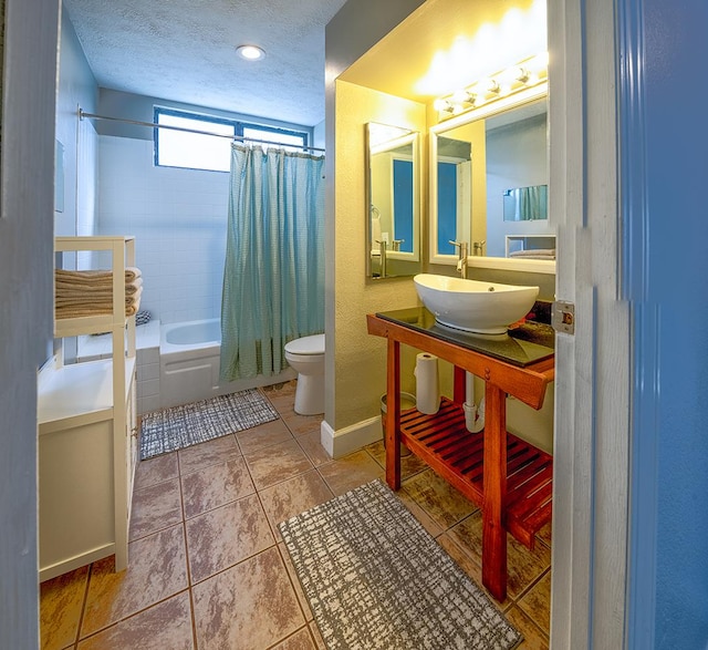 full bath featuring toilet, tile patterned floors, shower / bath combination with curtain, a textured ceiling, and a sink