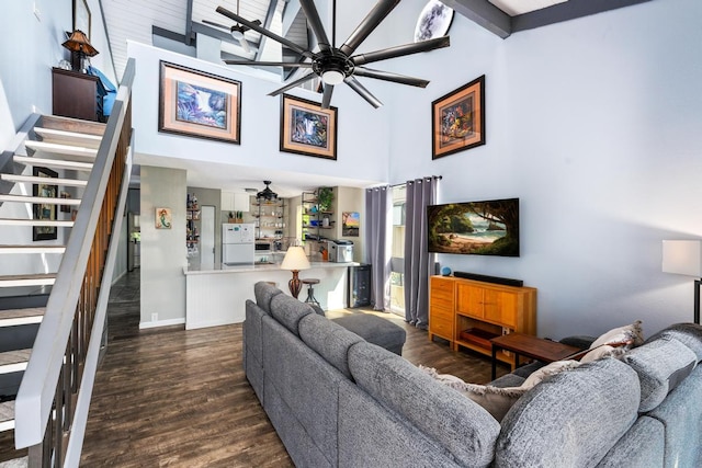 living room featuring baseboards, ceiling fan, stairs, a high ceiling, and wood finished floors