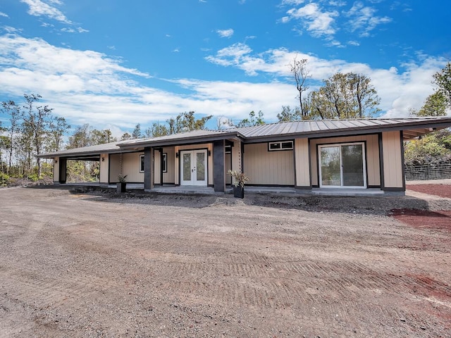 view of front of home with metal roof, a carport, and french doors