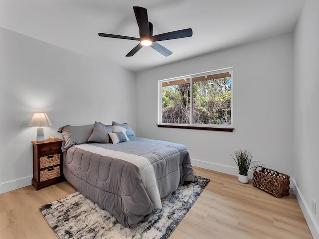 bedroom featuring ceiling fan, baseboards, and wood finished floors