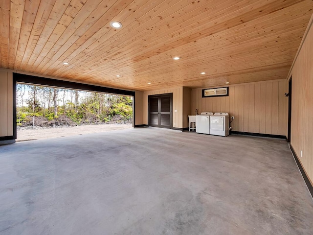 unfurnished living room with washing machine and dryer, recessed lighting, wood walls, concrete floors, and wood ceiling