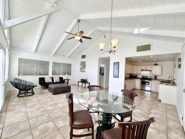 dining area with ceiling fan with notable chandelier, vaulted ceiling with beams, light tile patterned flooring, and visible vents