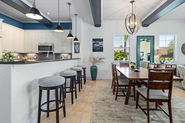 dining space featuring light tile patterned floors, plenty of natural light, and beamed ceiling