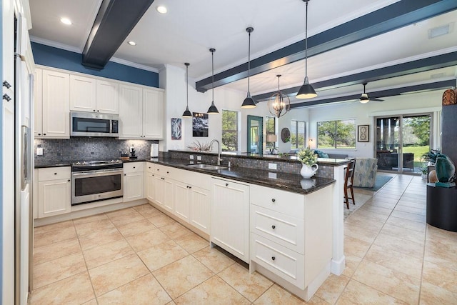 kitchen featuring open floor plan, beamed ceiling, a peninsula, stainless steel appliances, and a sink