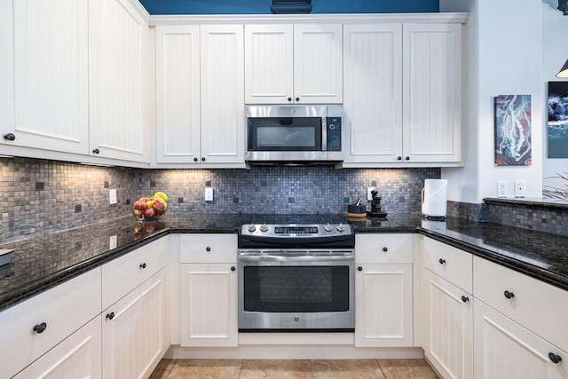 kitchen featuring white cabinetry, dark stone counters, backsplash, and appliances with stainless steel finishes