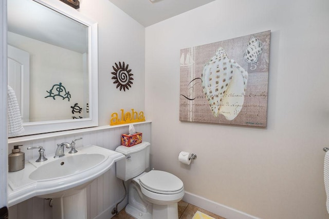 bathroom with baseboards and toilet