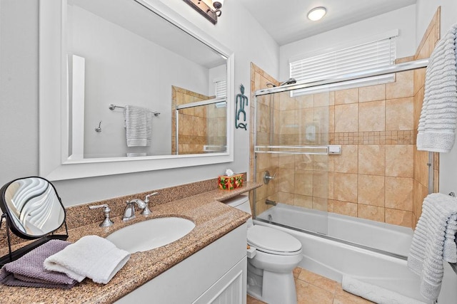 bathroom featuring shower / bath combination with glass door, toilet, vanity, and tile patterned flooring