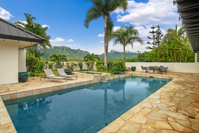 view of pool featuring a fenced in pool, a patio, a mountain view, and an in ground hot tub