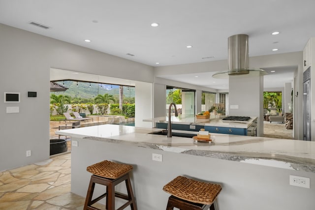 kitchen with visible vents, exhaust hood, light stone countertops, stone tile flooring, and recessed lighting