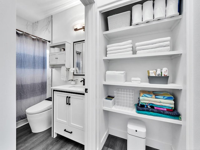 full bathroom with toilet, a shower with curtain, wood finished floors, and vanity