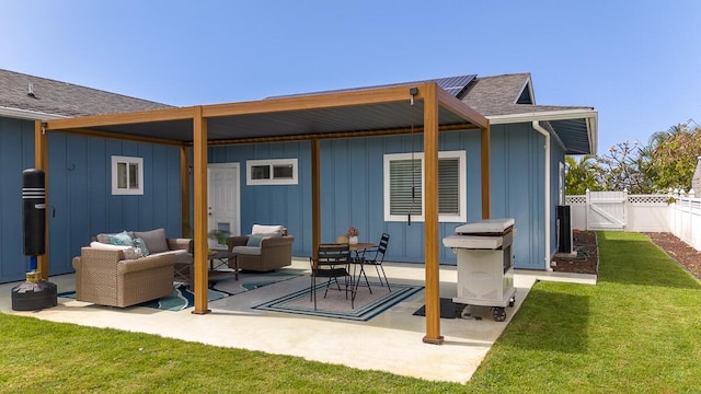 rear view of house with an outdoor hangout area, a gate, fence, a yard, and board and batten siding