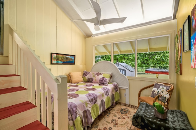 bedroom featuring wooden walls and vaulted ceiling