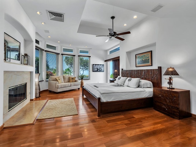bedroom featuring recessed lighting, visible vents, wood finished floors, and a high end fireplace