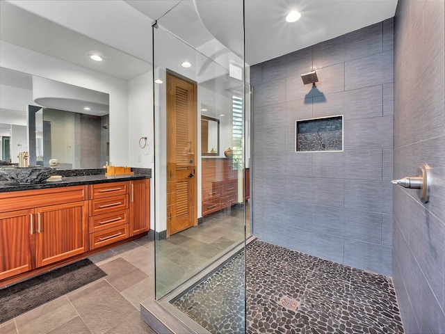 full bathroom with walk in shower, vanity, recessed lighting, tile patterned floors, and tile walls