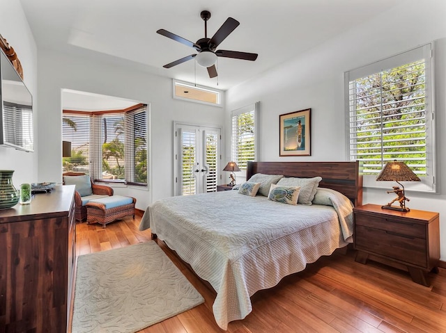 bedroom with access to exterior, french doors, a ceiling fan, and light wood-style floors
