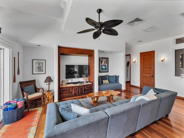 living room with visible vents, ceiling fan, and wood finished floors