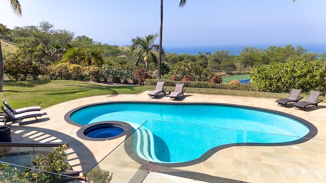 view of swimming pool with a lawn, a pool with connected hot tub, a patio, and fence