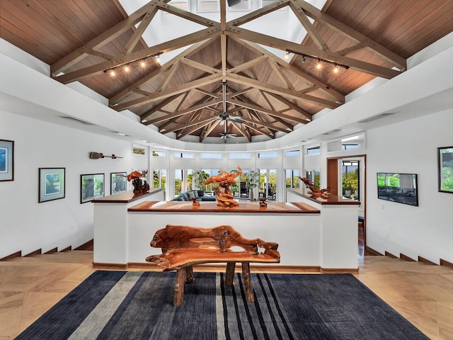 interior space with wood ceiling, beamed ceiling, a skylight, and high vaulted ceiling
