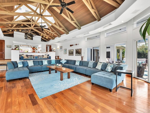 living area featuring ceiling fan, beam ceiling, high vaulted ceiling, and light wood-style flooring