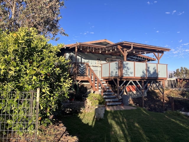 rear view of property with stairs, a yard, and a wooden deck