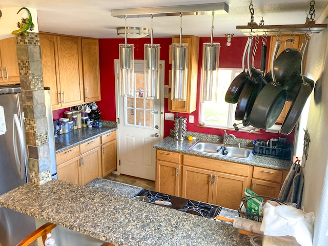 kitchen featuring dark countertops, brown cabinets, and a sink