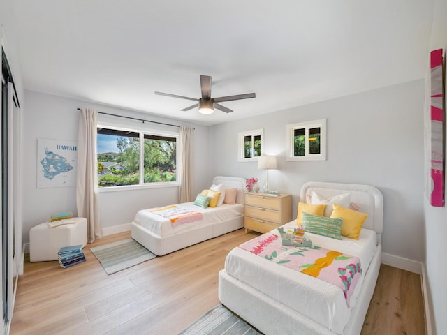 bedroom with baseboards, wood finished floors, and a ceiling fan