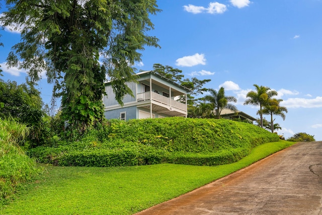 exterior space with a yard, stucco siding, and a balcony