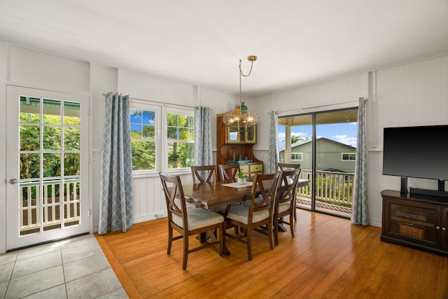 dining room with a notable chandelier, plenty of natural light, and light wood-style flooring