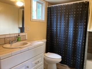 full bath featuring vanity, shower / bath combination with curtain, and toilet