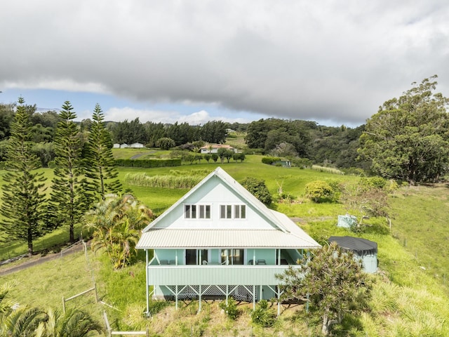 rear view of property featuring metal roof and a yard