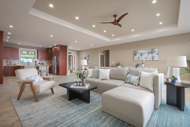 living area featuring a ceiling fan, recessed lighting, and a raised ceiling