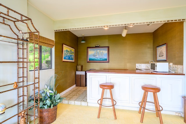 bar featuring baseboards and wallpapered walls