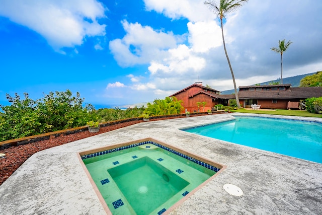 pool featuring a patio and an in ground hot tub