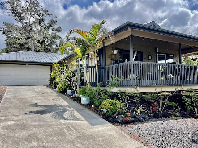 view of front of house featuring an attached garage, driveway, and metal roof