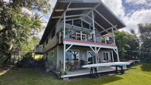 back of property featuring a lawn and a balcony