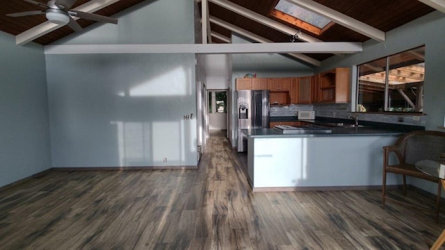 kitchen featuring dark countertops, dark wood-type flooring, ceiling fan, refrigerator with ice dispenser, and decorative backsplash