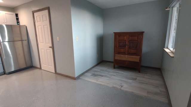 interior space with open shelves, baseboards, white cabinets, and freestanding refrigerator