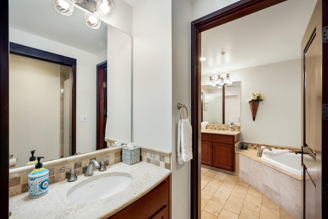 full bathroom with two vanities, a garden tub, and a sink