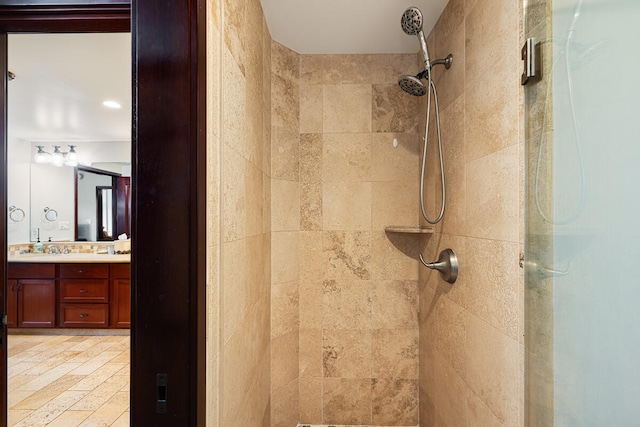 full bath with a sink, a shower stall, and double vanity