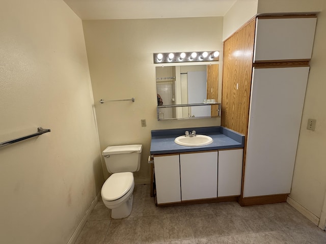 bathroom with tile patterned floors, baseboards, toilet, and vanity