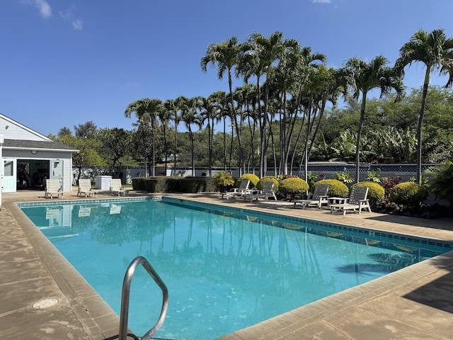 pool with a patio and fence