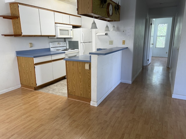 kitchen featuring light wood-style flooring, a peninsula, white cabinets, white appliances, and open shelves