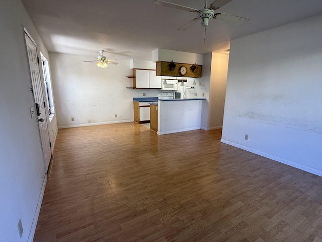 interior space featuring baseboards, ceiling fan, and dark wood-style flooring