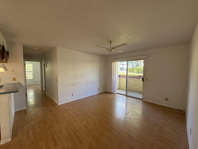 unfurnished room featuring a ceiling fan, light wood-style floors, and baseboards