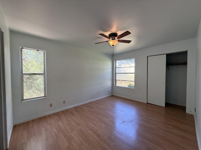 unfurnished bedroom featuring wood finished floors, baseboards, and ceiling fan