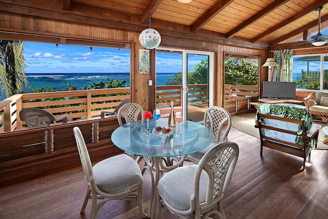 sunroom with lofted ceiling with beams, wood ceiling, a water view, and a healthy amount of sunlight